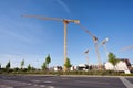 Construction site with cranes, next to a main street, on a blue, sunny day Royalty Free Stock Photo