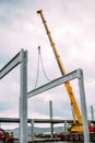 Construction site details - crane lifting a precast concrete cement beam to building assembly Royalty Free Stock Photo