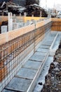 Construction site details - house building. Reinforced steel bars in wooden casing Royalty Free Stock Photo