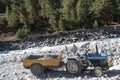 Construction site dumper Dump truck Lorry with heavy load capacity tipping earth rock sands and boulders from riverbank foundation