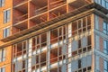 A construction site at dusk showcases a tall, multi-story building in progress The structure features red brickwork and glass Royalty Free Stock Photo
