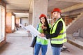 Construction site engineers with blueprints wearing hard hats Royalty Free Stock Photo