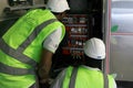 Construction site with engineers and workers fixing a machine in a factory - wiring and electronics