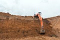 The construction site excavator digs a deep pit. Digger. Construction machinery. Excavation at a construction site Royalty Free Stock Photo