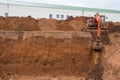 The construction site excavator digs a deep pit. Digger. Construction machinery. Excavation at a construction site Royalty Free Stock Photo