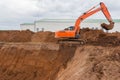 The construction site excavator digs a deep pit. Digger. Construction machinery. Excavation at a construction site Royalty Free Stock Photo