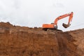 The construction site excavator digs a deep pit. Excavation at a construction site Royalty Free Stock Photo