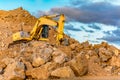 Construction site with an excavator moving rock