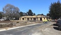 construction workers walking on a paved road near a large wooden framed building under clear blue sky during daytime Royalty Free Stock Photo
