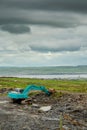 Construction site in a field with blue color excavator working. Dark dramatic sky,