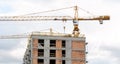 Construction site, generic unfinished empty residential building and a crane, block of flats under construction, new modern estate Royalty Free Stock Photo