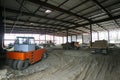 Construction site of a hangar building, an excavator and dump trucks loaded Royalty Free Stock Photo