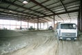 Construction site of a hangar building, an excavator and dump trucks loaded Royalty Free Stock Photo