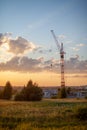 High-rise cranes build a house on the background of a beautiful sunset Royalty Free Stock Photo