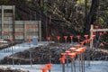 Construction site on hillside with footings poured and rebar with orange safety caps Royalty Free Stock Photo