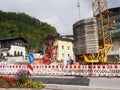 Construction site with houses a crane concrete weights and barriers with a forest in the background