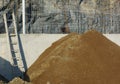 Construction site ladder and heap of gravel Royalty Free Stock Photo