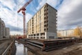 construction site with large crane lifting heavy materials, such as steel beams or concrete blocks