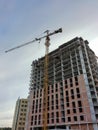 Construction site. A large industrial tower crane near an unfinished tall building. Modern civil construction Royalty Free Stock Photo