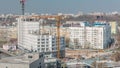 Construction site with lots of yellow cranes next to the road timelapse, aerial view