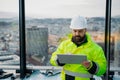 Construction site manager using digital tablet to inspect building progress. Royalty Free Stock Photo