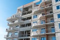 The construction site of a multi-storey residential building made of white brick against a blue sky background. View of the new Royalty Free Stock Photo