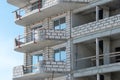 The construction site of a multi-storey residential building made of white brick against a blue sky background. View of the new Royalty Free Stock Photo