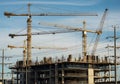 Construction site with multiple cranes against a blue sky Royalty Free Stock Photo