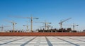 Construction Site with Multiple Tower Cranes and Building Frameworks Under a Clear Blue Sky development Royalty Free Stock Photo