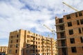 Construction site of a new apartment high building with tower cranes against blue sky. Residential area development. Real estate p Royalty Free Stock Photo