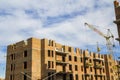 Construction site of a new apartment high building with tower cranes against blue sky. Residential area development. Real estate p Royalty Free Stock Photo