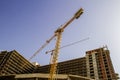 Construction site. New building. Yellow tower crane against blue sky. Royalty Free Stock Photo