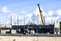 Construction site of a new industrial building, concrete block walls, columns and a telescopic crane Royalty Free Stock Photo