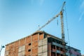 Construction site of new residential building with apartments and offices with crane and scaffolds against blue sky Royalty Free Stock Photo