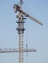 A construction site of new residential buildings and high rise with cranes to transport heaving objects, selective focus of crane Royalty Free Stock Photo