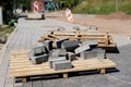 Construction site for a new road for cars. Laying paving blocks, new wells along the road.