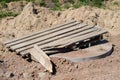 Construction site for a new road for cars. Laying paving blocks, new wells along the road.