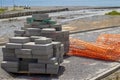 Construction site for a new road on the embankment near the sea. Building blocks on the background of the construction site and Royalty Free Stock Photo