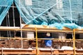 Construction site of old apartment building with scaffolding and a busy mason worker. Bricklayer bricking a new row of bricks on Royalty Free Stock Photo