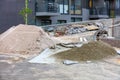 A construction site with a pile of sifted sand and cement in the background of a new residential building in the open