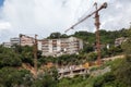 Construction site of public buildings on hills near sea coastline. Cranes during lifting operations Royalty Free Stock Photo