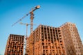 Construction site with reinforced concrete and brick buildings and cranes. Royalty Free Stock Photo
