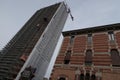 Construction site for the renovation of a skyscraper in Milan. Lift and tower crane. Art nouveau brick house