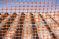 Construction site with safety plastic orange grid and old aged dangerous asbestos roof - concept image