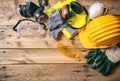 Construction safety. Protective hard hat, headphones, gloves and glasses on wooden background, copy space, top view Royalty Free Stock Photo