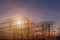 Construction site with scaffold tower and warning label building with dusk background,scaffolding for construction factory