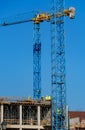 Construction site with scaffolding, crane and workers, building frame under construction Royalty Free Stock Photo
