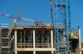 Construction site with scaffolding, crane and workers, building frame under construction Royalty Free Stock Photo