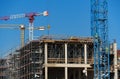 Construction site with scaffolding, crane and workers, building frame under construction Royalty Free Stock Photo
