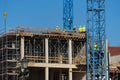 Construction site with scaffolding, crane and workers, building frame under construction Royalty Free Stock Photo